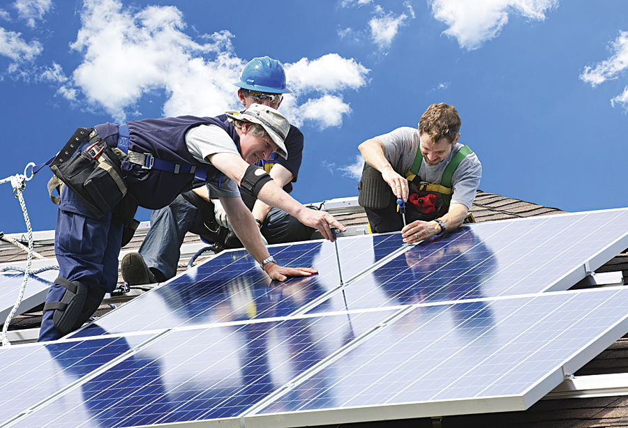 ロサンゼルスの建物の屋上で行われているソーラーパネル設置作業。