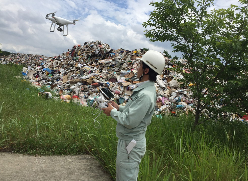 仮置場でドローンを飛ばす前田氏