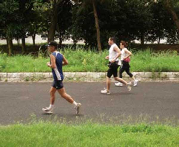 つくば市内の公園をジョギングする人々
