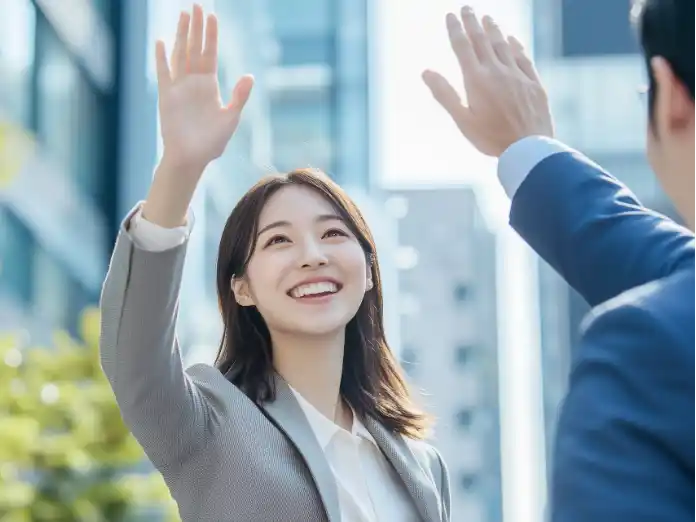 明るい表情でハイタッチするビジネスパーソン。Esriジャパンの職場環境や採用情報を紹介